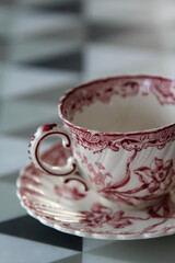 White ceramic coffee cup with pink flower pattern on the table.