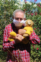 un homme vieux et son vieux ours en peluche portant un masque de protection contre le coranovirus