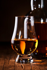 Scotch Whiskey without ice in glasses and bottle, rustic wood background, copy space