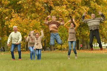 Fototapeta premium Happy smiling family relaxing in autumn park jumping