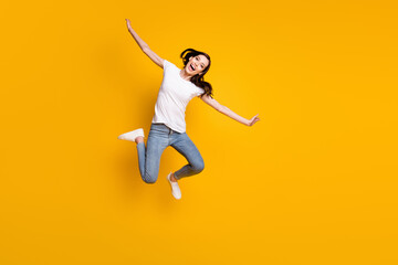 Fototapeta na wymiar Full length body size view of her she pretty cheerful cheery careless thin girl jumping flying like plane wings having fun active life isolated bright vivid shine vibrant yellow color background