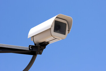 Rectangular shape video surveillance camera on the street on blue sky background