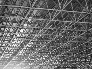 Metal truss frame roof of factory in black and white color with flare.