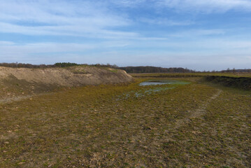 The exposed bottom of a dry pond. A shallow water body.
