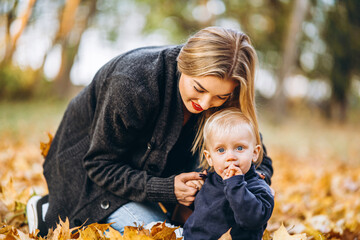 Happy mother with her little baby son have fun in the city park