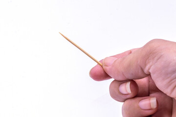 Close up hand holding wooden toothpick isolate on white background.