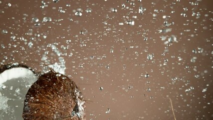 Super slow motion of coconut pieces flying in the air with water splashes. Filmed on high speed cinema camera, 1000 fps.