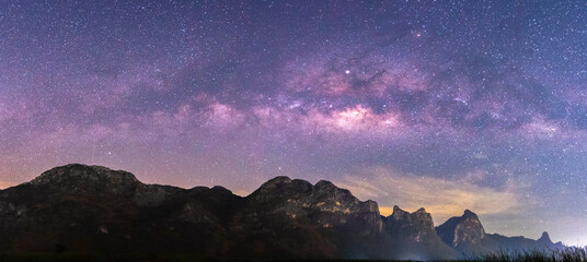 Panorama landscape view of Milky Way in night sky over mountain. Recreation and outdoor travel