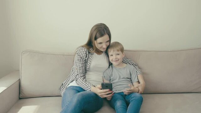 Mom and son play games on the phone together. Educational games. 4k video
