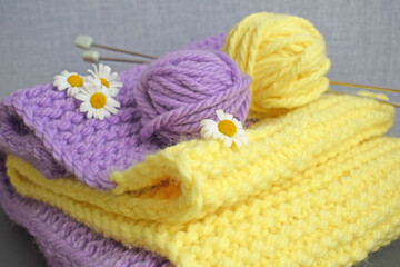 Obraz na płótnie Canvas A warm lilac-yellow scarf, knitted with thick yarn.Handmade work.