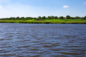 Blue lake on the background of green slopes in the village