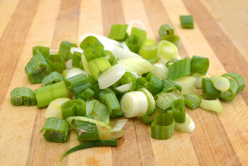 Cut green onion isolated on the wooden board