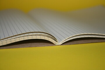 a paper new notebook on a yellow background