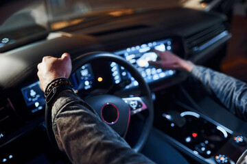 Using navigation display. Handsome unshaved man in fashionable clothes riding his automobile