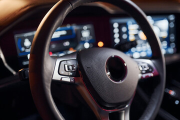 Steering wheel and navigation display. Close up view of front park of new modern black automobile