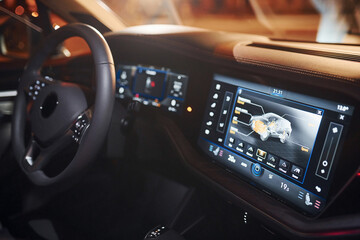 Steering wheel and navigation display. Close up view of front park of new modern black automobile