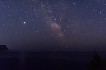The milky way over the sea. Beautiful starry sky. Watching shooting stars. The path of the...