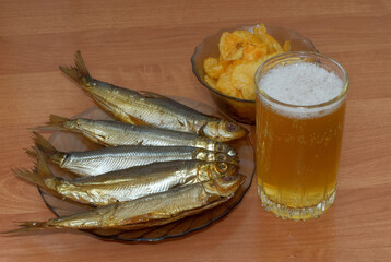 Стакан пива с копченой рыбой и картофельными чипсами
