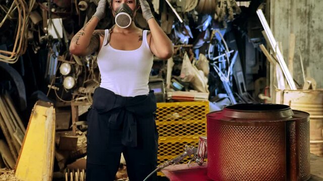 Attractive young woman mechanical worker repairing a vintage car in old garage.