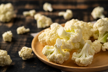 Sliced Cauliflower into small pieces on wooden plate