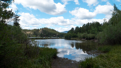 Fototapeta na wymiar Clouds reflecting of the water of the beautiful private Lake Hiawatha in Red Feather Lakes, Colorado.