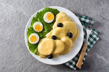 Traditional Peruvian papa a la huancaina on gray background. Top view	