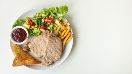 Pork steak with salad, bread, and barbecue sauce on a white plate with copy space on the right.