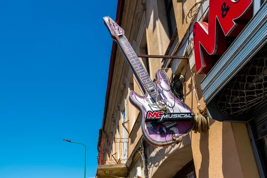 Brasov, Romania- 06 August 2020: MC musical street sign in the shape of a  guitar on old building. Stock Photo | Adobe Stock