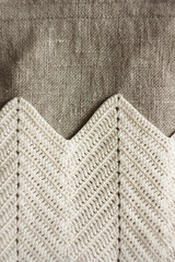 Crossbody bag close-up. Linen bag. Knitted white decor. Background