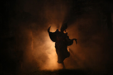 silhouette of women in traditional dancer against burning fire in the dark