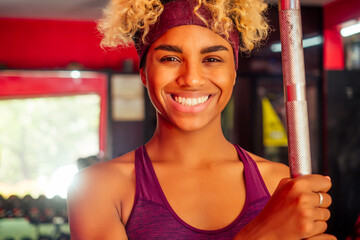 sporty african american woman pull-up athletic iron indoors