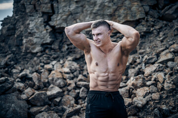 Handsome male with perfect body. Hands on a head. Strong hands. Male beauty concept.