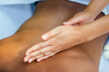 brazilian woman getting back and shoulders massaging in outdoor spa Ayurveda centre in India green tropical background