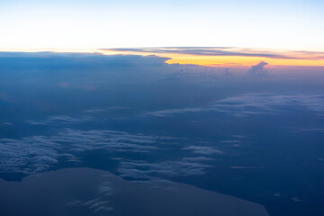 Obraz premium View from the plane window to the evening sky. Beautiful landscape from the plane window. Flying above the clouds. Warm blue shades of the twilight sky.
