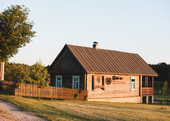 old wooden house in village. Farmhouse in Belarus. View of rustic ethnic house on sunset. rural landscape