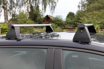 Fototapeta na wymiar Transverse aluminum aerodynamic rails with a locks on the roof of a passenger car, upper trunk equipment fastening for transportation