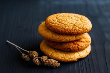 oatmeal cookies next to a spike on a dark wooden background
