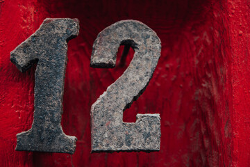  Metallic number twelve on red wooden background