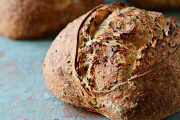 Homemade Freshly Baked Country Bread  made from wheat and whole grain flour on a dark background. French Freshly baked bread. 