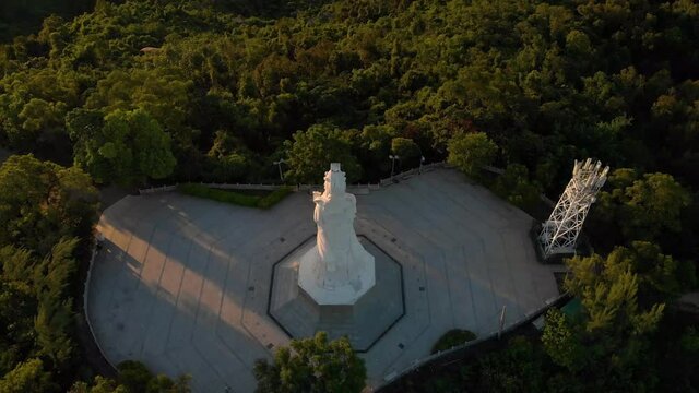 Aerial tilt reveal of Goddess A-Ma statue and stunning Macau cityscape