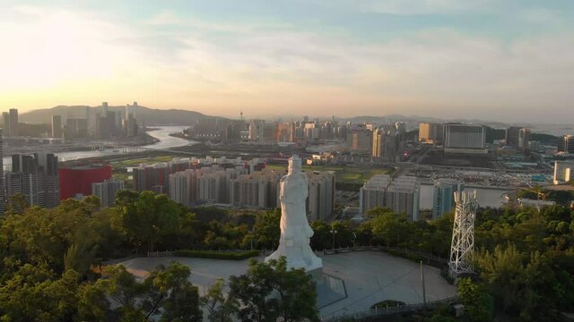 Aerial shot approaching Goddess A-Ma statue from behind with Macau skyline