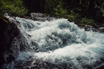 Big rapids of powerful mountain river. Beautiful background with azure water in fast river. Frozen motion of tall mountain river rapids. Power majestic nature of highlands. Backdrop of aqua turbulence