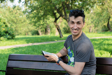 A man reads a kindle in the Park