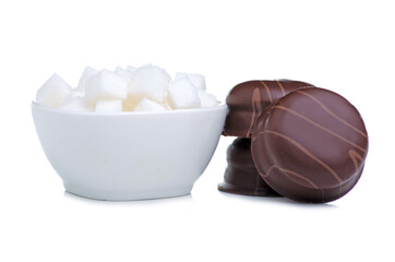 White bowl with sugar cubes and sweets candy on white background isolation