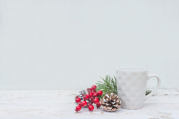 Christmas and winter template. White modern mug and christmas decorations, holly berries on white...