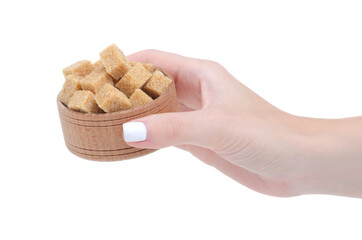 Wooden bowl with cane brown sugar cubes in hand on white background isolation
