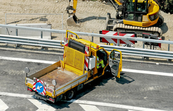 Lavori autostradali su careggiata: camion giallo con attrezzature a bordo di segnalazione e sicurezza. 