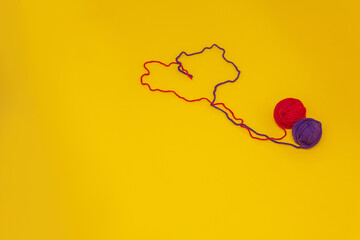 heart of red and blue thread, unraveled from a tangle on an orange background