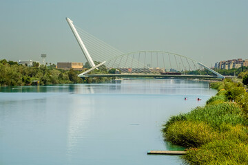 A view from the east bank of the river Guadalquivir towards the Barqueta Bridge in Seville, Spain in summertime