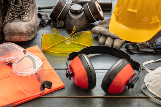 Work safety protection equipment background. Industrial protective gear on wooden table